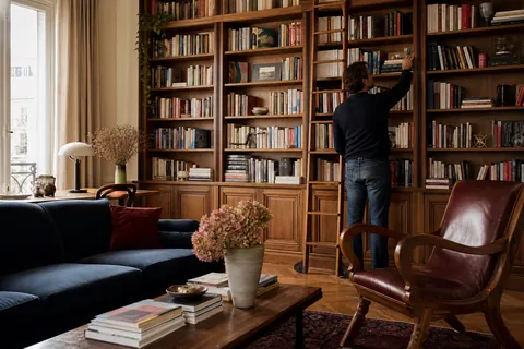 Lecteur choisissant un livre dans sa bibliothèque personnelle
